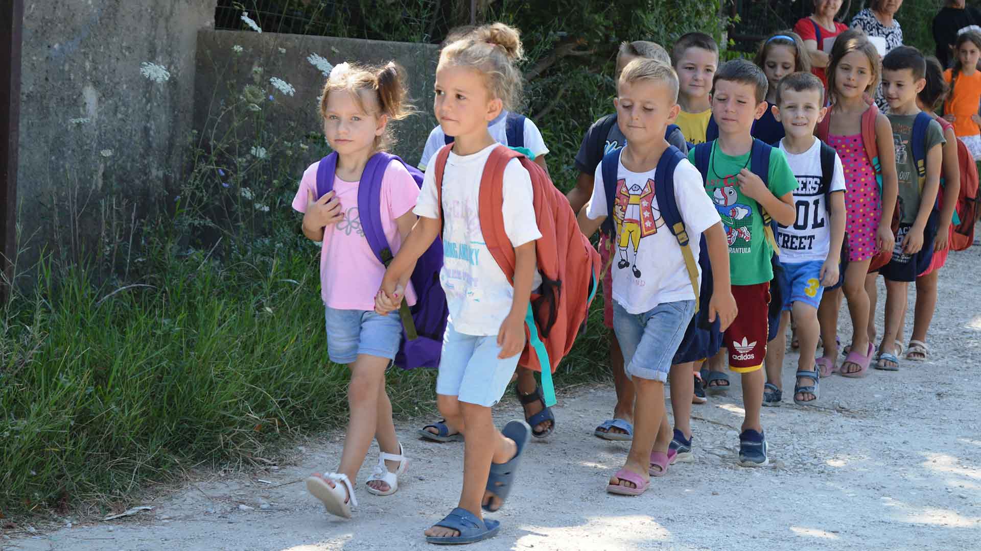 A child walks to school with a new bag.