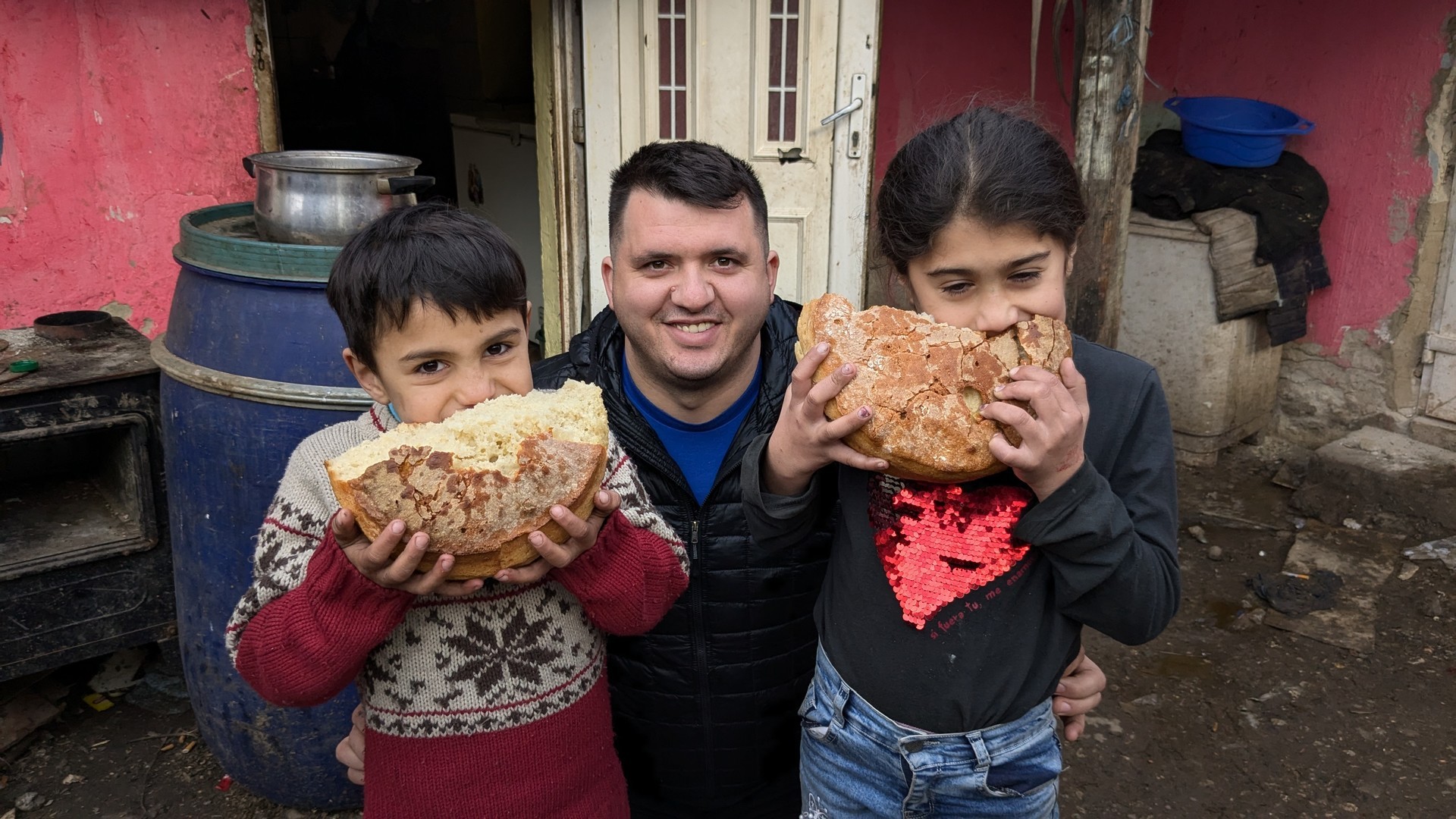A boy and a girl trying a loaf of fresh bread with the MWB coordinator who delivered it