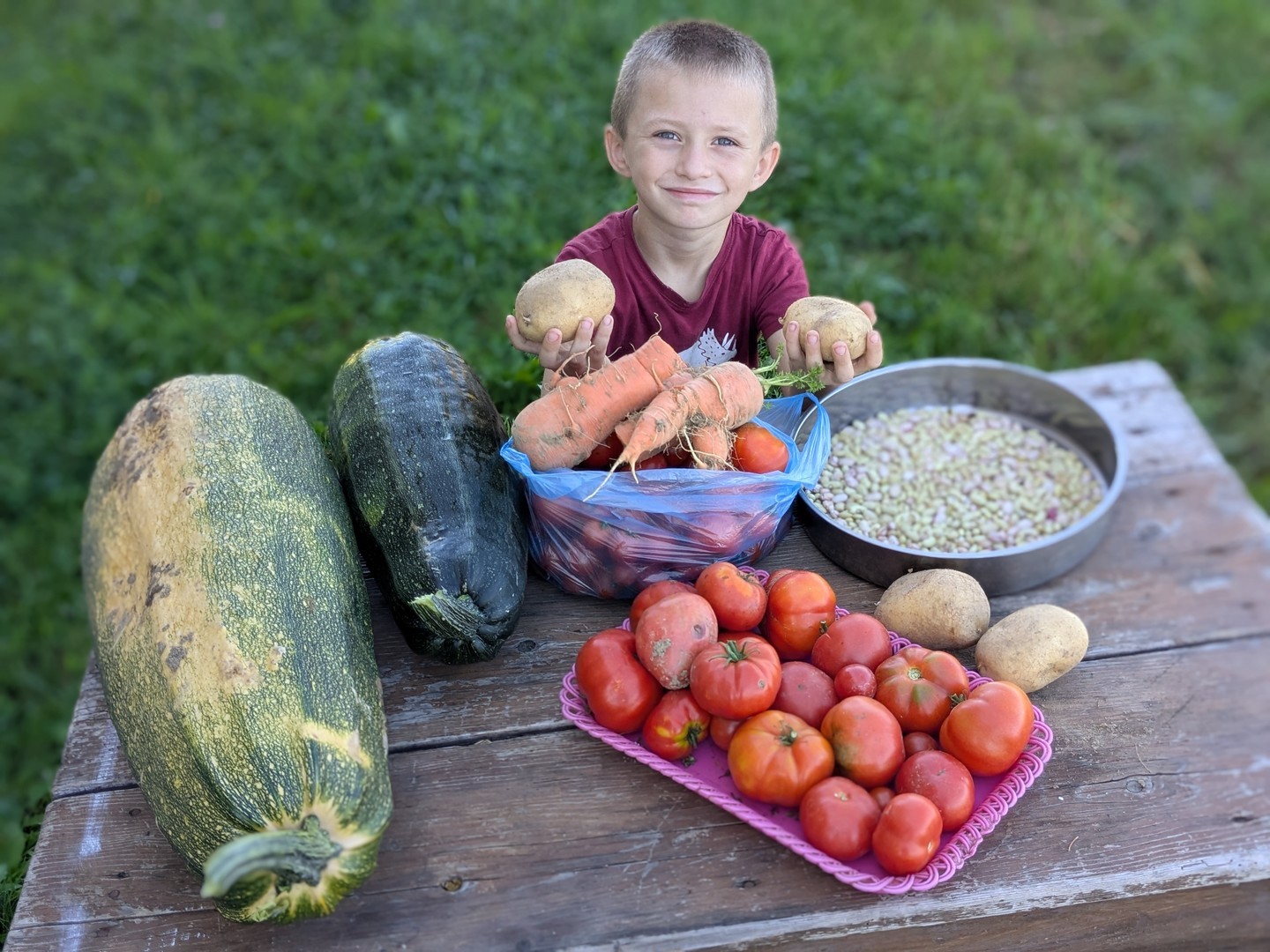 A young boy showing off vegtrables